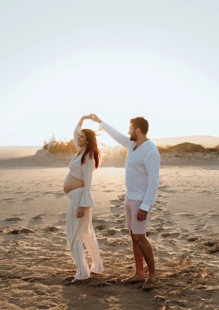 Séance photo de grossesse en bord de plage. Couple qui danse à Gruissan